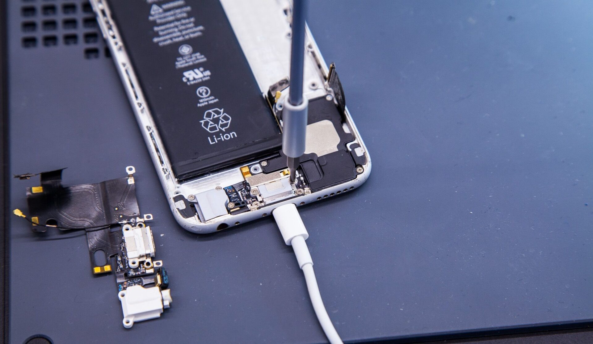 An iPhone charging connector being serviced