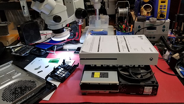Xbox console opened on a repair workbench